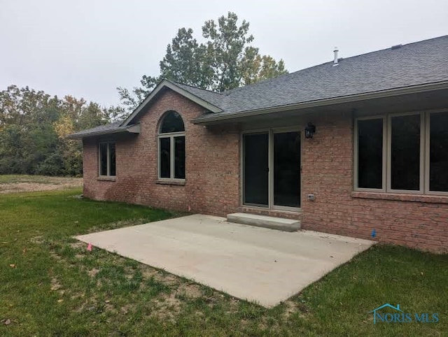 back of property with a patio area and a lawn