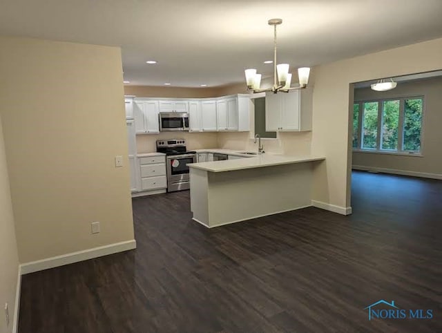 kitchen featuring appliances with stainless steel finishes, sink, kitchen peninsula, white cabinets, and dark wood-type flooring