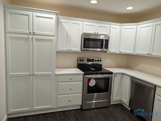 kitchen featuring stainless steel appliances, dark hardwood / wood-style floors, and white cabinets