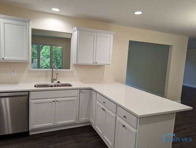 kitchen with kitchen peninsula, dark hardwood / wood-style flooring, white cabinetry, stainless steel dishwasher, and sink