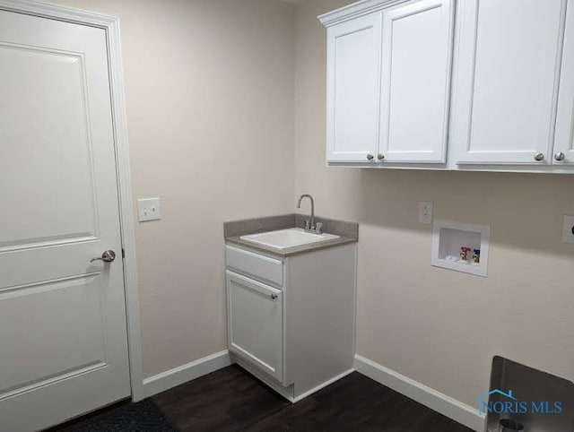 laundry area featuring sink, hookup for a washing machine, dark wood-type flooring, and cabinets