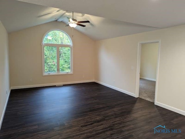 unfurnished room featuring vaulted ceiling, dark hardwood / wood-style floors, and ceiling fan