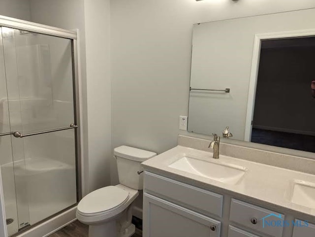 bathroom with vanity, toilet, and a shower with shower door