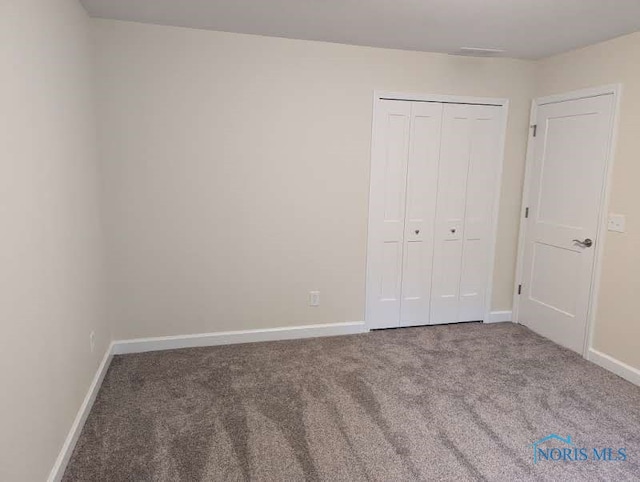 unfurnished bedroom with carpet and a closet