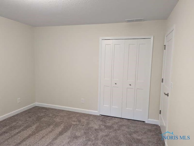 unfurnished bedroom featuring carpet floors and a closet