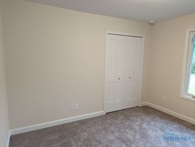 unfurnished bedroom with a closet and carpet flooring