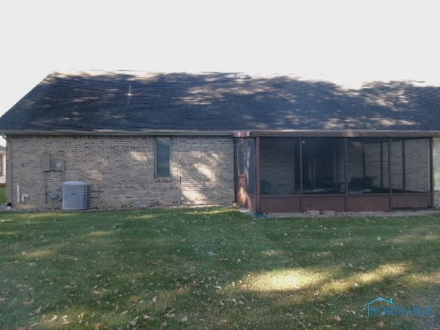 rear view of property featuring central AC, a yard, and a sunroom