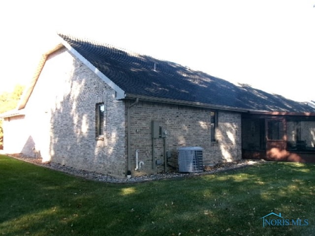 view of side of property featuring a yard and cooling unit