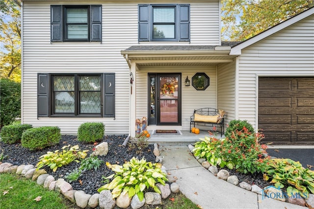 doorway to property with a garage and covered porch