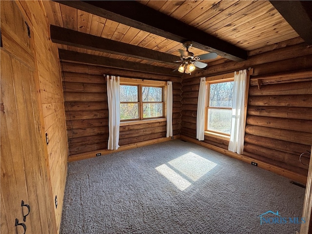 empty room with beam ceiling, rustic walls, ceiling fan, wooden ceiling, and carpet