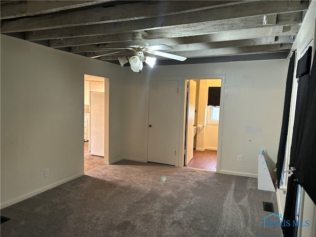 unfurnished bedroom with carpet, ceiling fan, beam ceiling, and connected bathroom