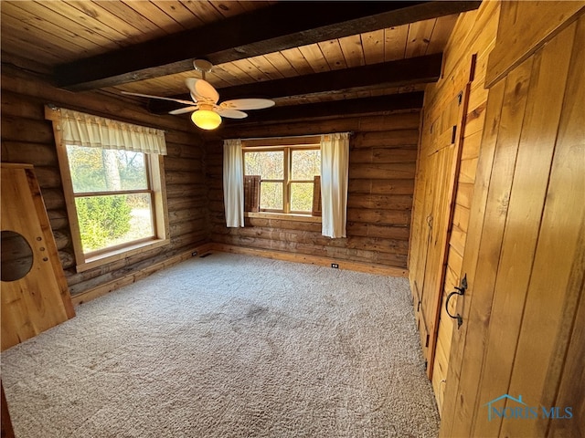 spare room featuring beam ceiling, ceiling fan, carpet floors, and wooden ceiling