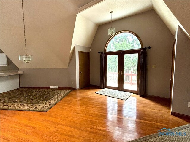 foyer featuring a notable chandelier, vaulted ceiling, and hardwood / wood-style floors