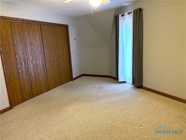 unfurnished bedroom featuring light colored carpet, a closet, and ceiling fan