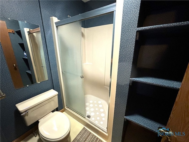 bathroom with a shower with door and toilet