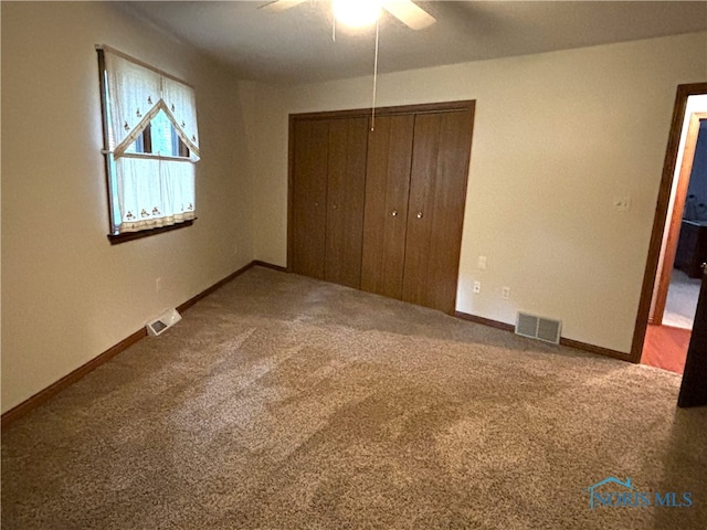 unfurnished bedroom featuring a closet, ceiling fan, and carpet floors