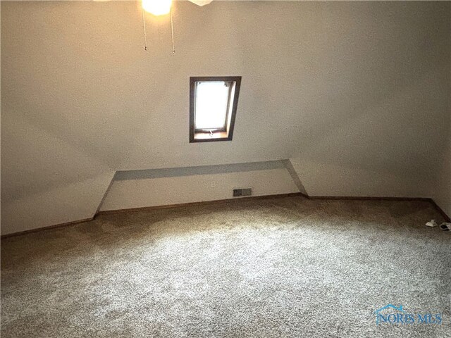 additional living space with ceiling fan, carpet flooring, and vaulted ceiling