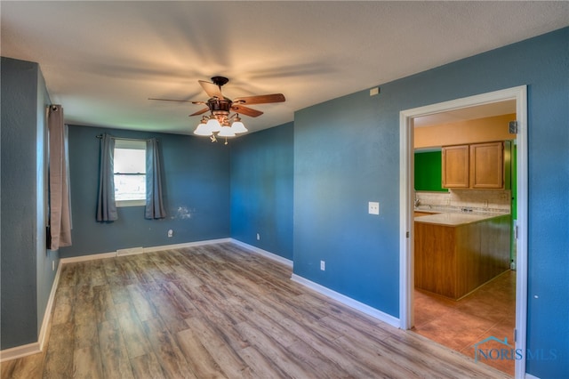 spare room featuring ceiling fan and light wood-type flooring