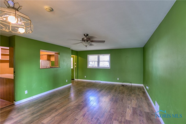 spare room featuring dark wood-type flooring and ceiling fan