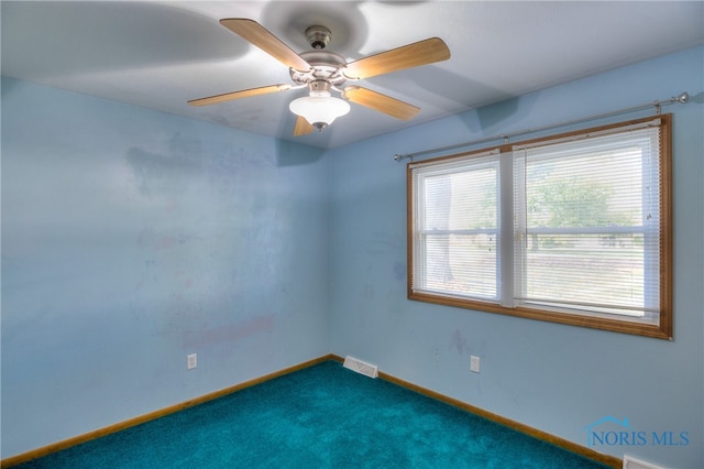 unfurnished room featuring dark carpet and ceiling fan