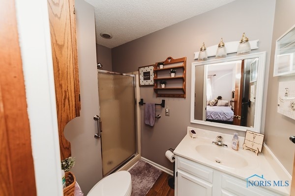 bathroom with vanity, wood-type flooring, toilet, and walk in shower