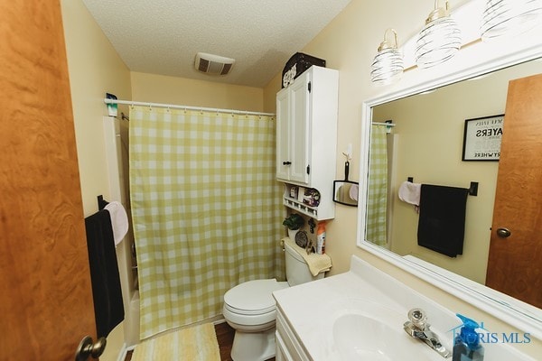 bathroom with vanity, toilet, a textured ceiling, and a shower with shower curtain