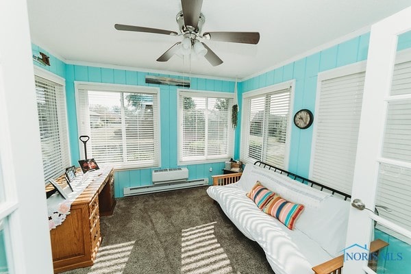 sunroom featuring a baseboard heating unit and ceiling fan