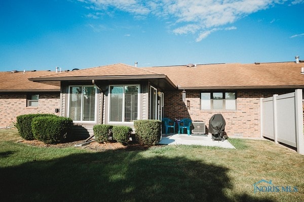 back of property featuring a patio area and a yard