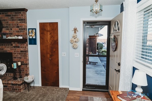 foyer entrance featuring a textured ceiling, dark hardwood / wood-style flooring, and a chandelier