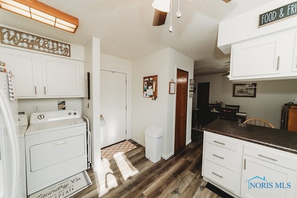 kitchen with a textured ceiling, washer and clothes dryer, dark hardwood / wood-style floors, and white cabinetry