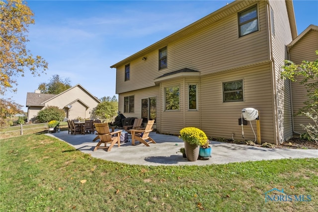 rear view of property with a yard and a patio