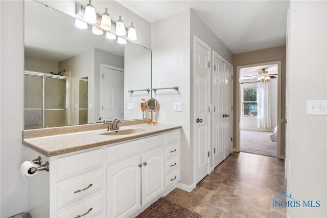 bathroom with vanity, a shower with shower door, and ceiling fan