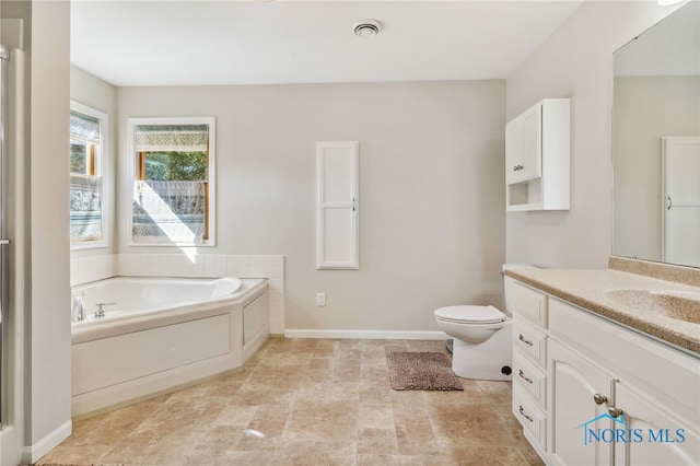 bathroom with vanity, a tub to relax in, and toilet