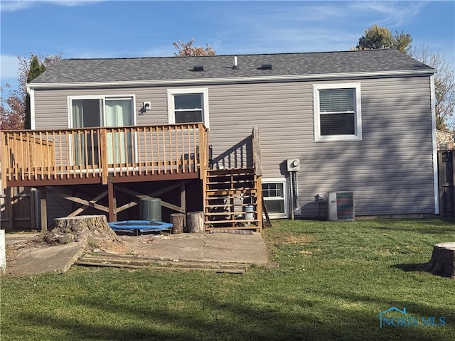 rear view of house featuring a yard and a deck