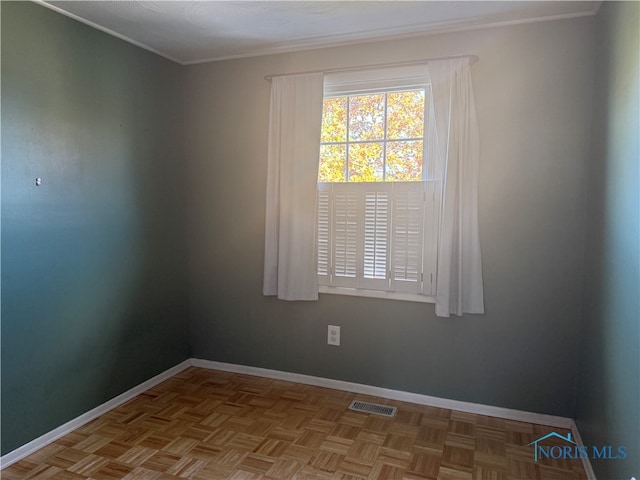 spare room featuring ornamental molding and light parquet floors