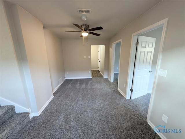 empty room with dark carpet and ceiling fan