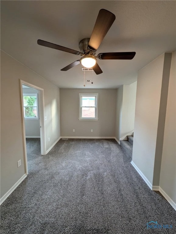 carpeted spare room featuring ceiling fan