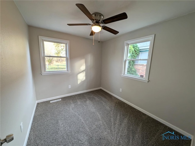 carpeted spare room featuring ceiling fan and a healthy amount of sunlight