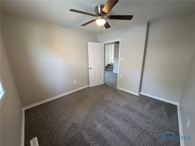 carpeted spare room featuring ceiling fan