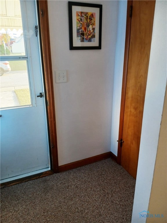 corridor featuring dark colored carpet