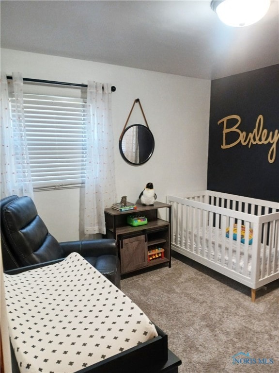 carpeted bedroom featuring a crib