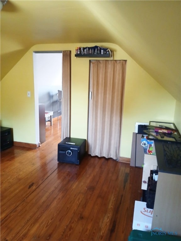 additional living space with lofted ceiling and dark hardwood / wood-style floors