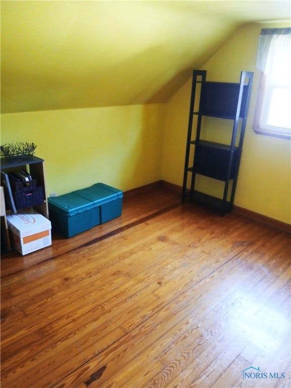 bonus room with vaulted ceiling and light hardwood / wood-style flooring