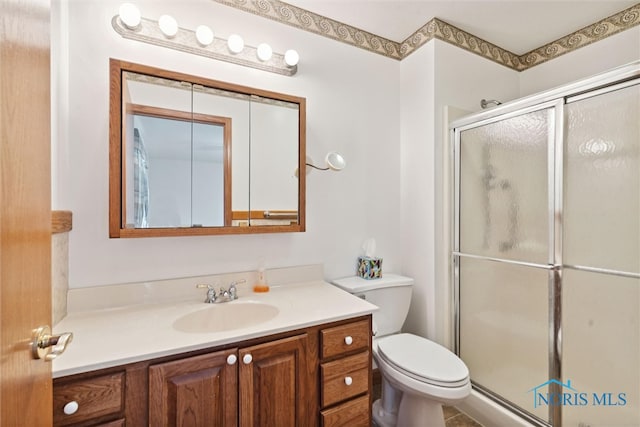 bathroom featuring toilet, an enclosed shower, and vanity