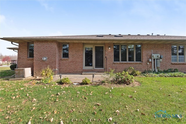 back of house featuring cooling unit and a lawn