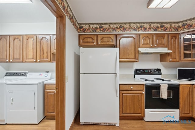 kitchen with washer and clothes dryer, light wood-type flooring, and white appliances