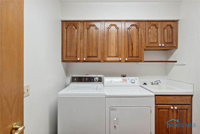 washroom with cabinets, sink, and washing machine and dryer