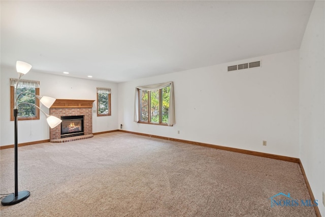 unfurnished living room with a fireplace and carpet