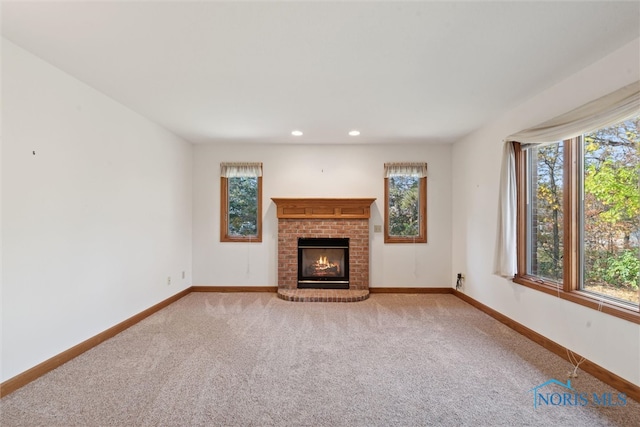 unfurnished living room with carpet floors and a fireplace