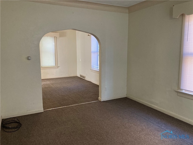 unfurnished room featuring dark carpet